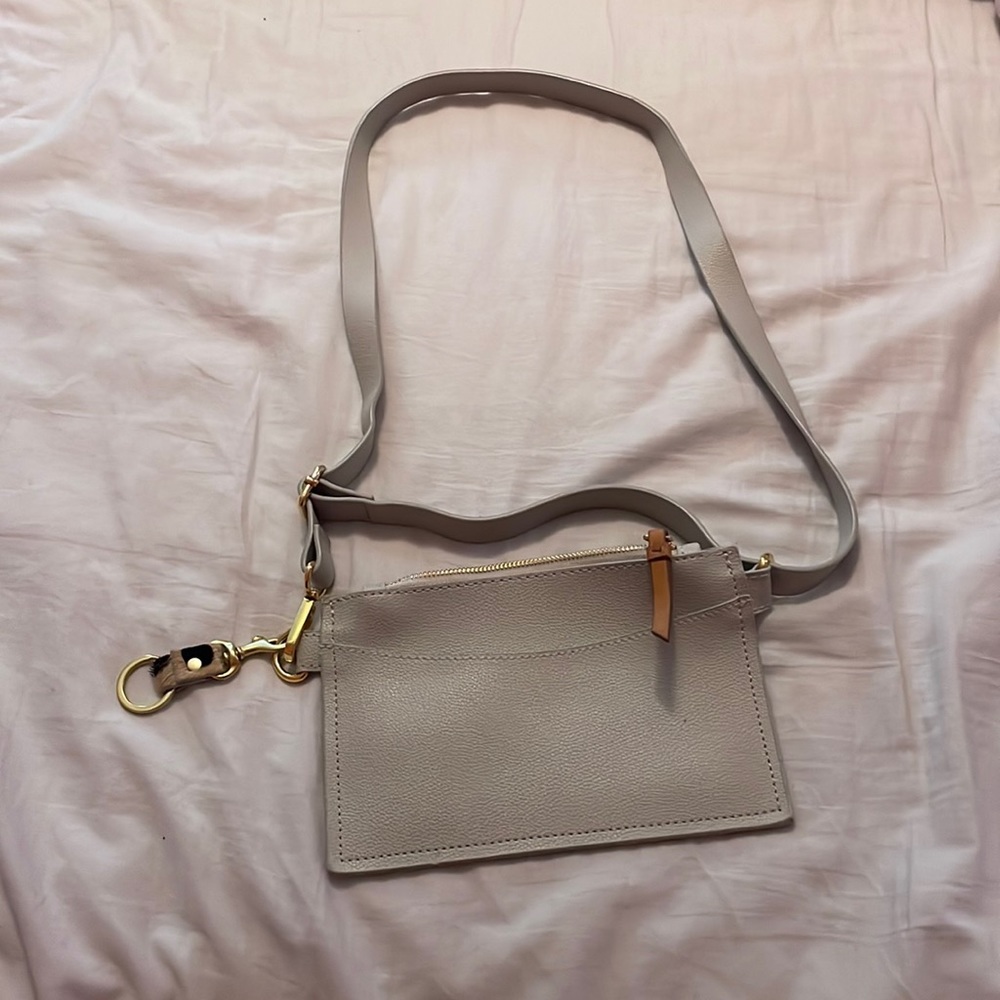Grey purse/handbag with outside pocket and gold zipper and gold attachment piece